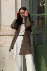 a lady in a beige top, a pair of white pants and a brown cashmere and wool coat